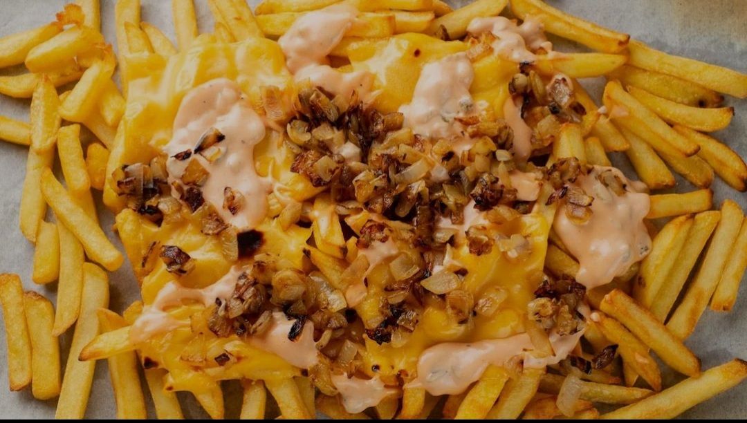 CSP box loaded with chips, cheesesteak filling and sauce.